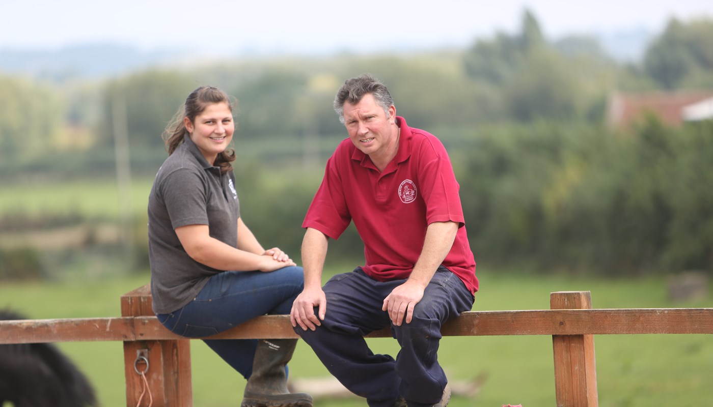 Walnut Tree Farm Somerset dairy farm owners sat on farm fence