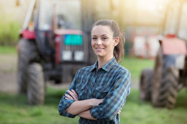 Female Farmer Standing in front of Tractor