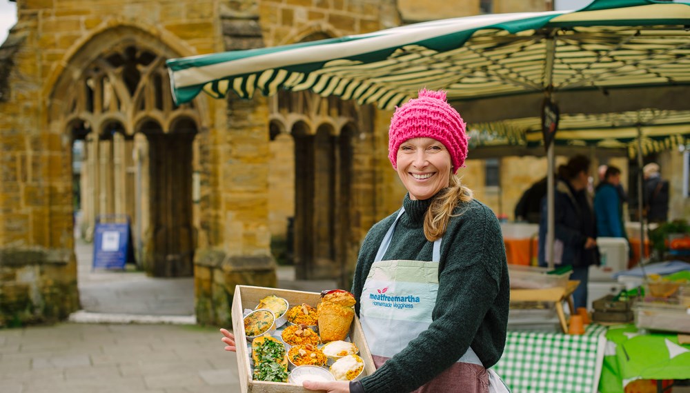 Dorset Farmers Market committee member and stallholder Karen Welford holding box of fresh food
