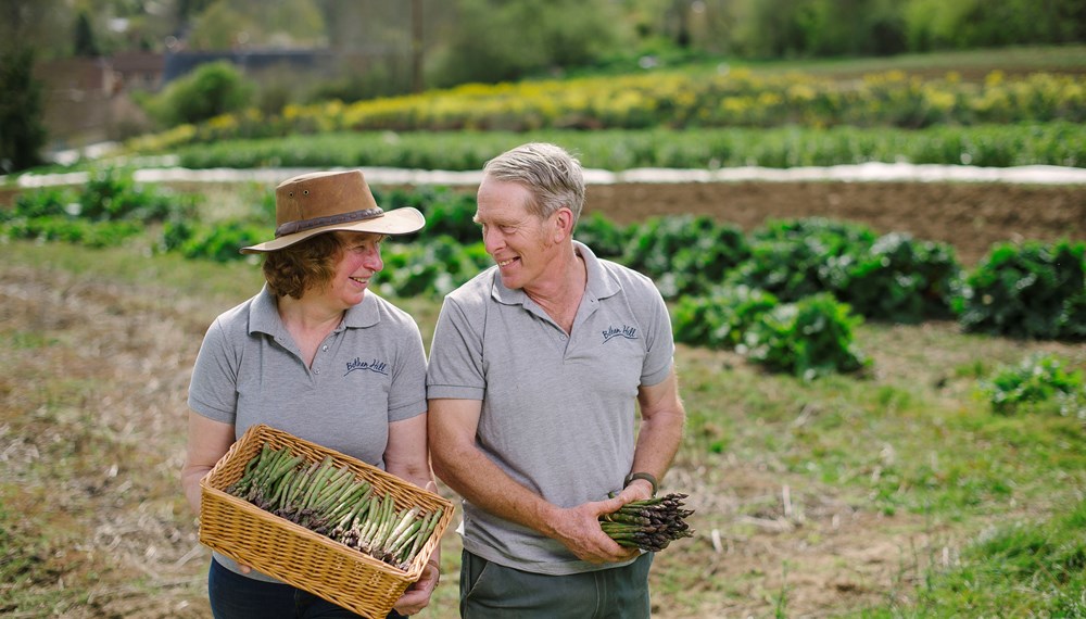 Bothen Hill Dorset Chip and Anita De-Greef holding their homegrown asparagus